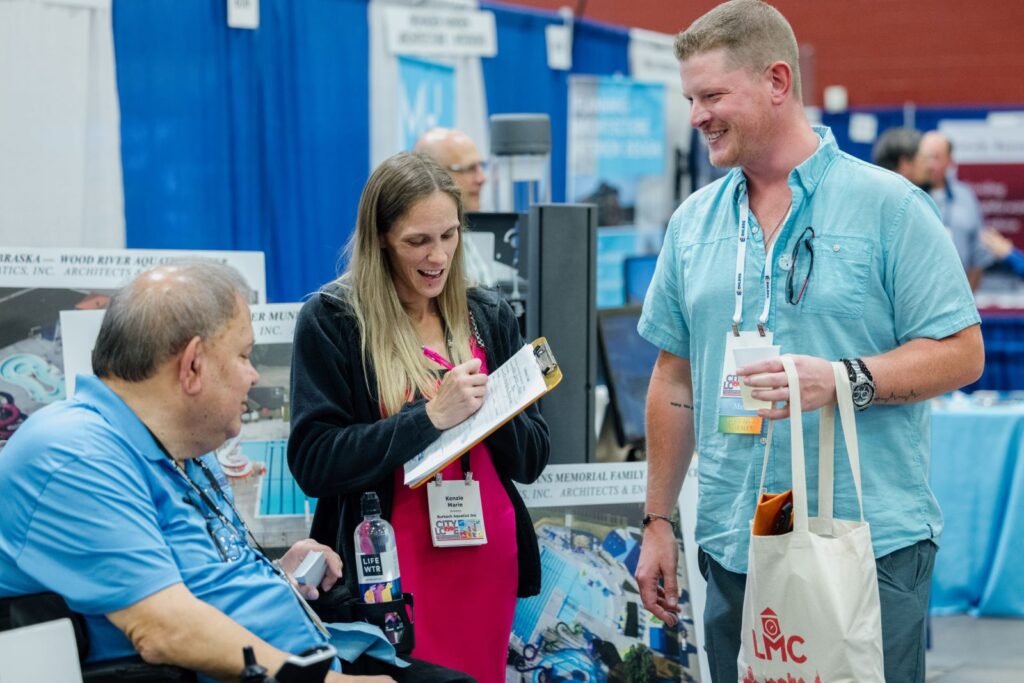 Members and vendors are shown connecting at the 2023 LMC Annual Conference Exhibit Hall.