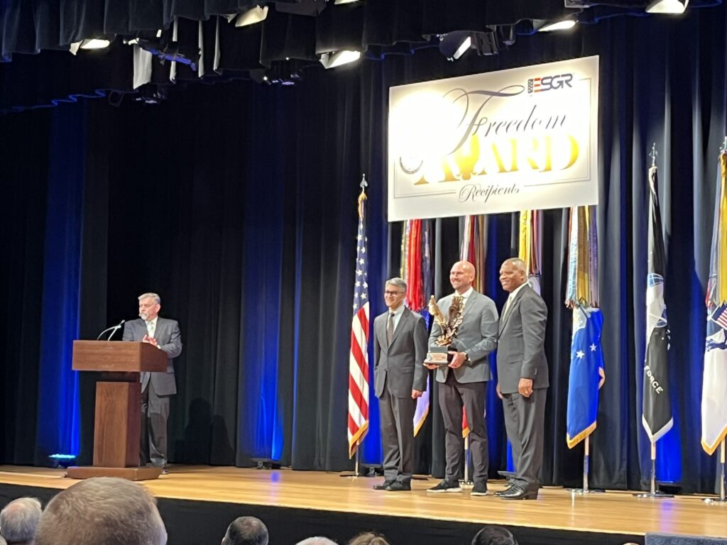 LMC Executive Director Luke Fischer receives the Freedom Award on stage at the Pentagon.