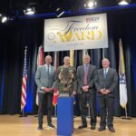 LMC Executive Director Luke Fischer receives the Freedom Award on stage at the Pentagon.