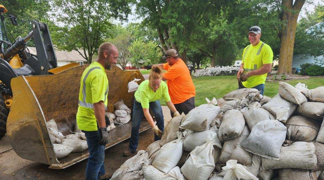 Volunteers are shown collecting sandbags