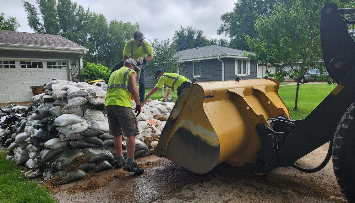 Volunteers are shown using a truck to pick up sandbags in Windom.