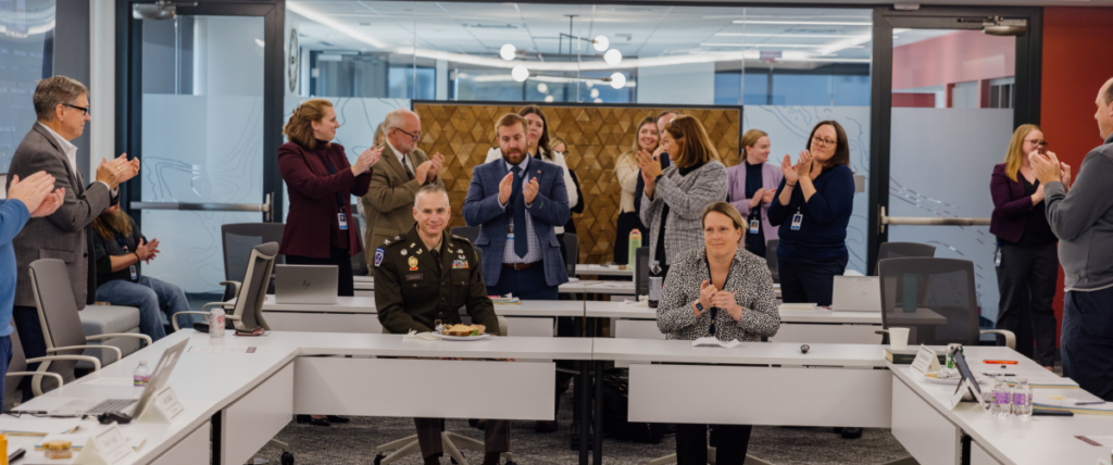 League staff and board members are shown applauding staff veterans.